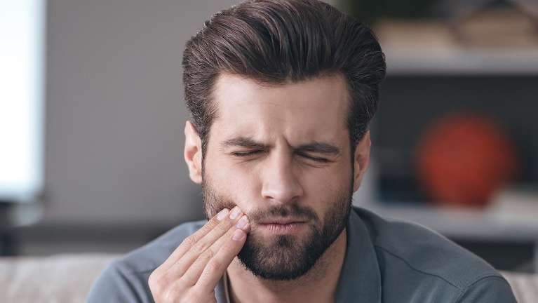 Man holding his right face with tooth pain in Winchester