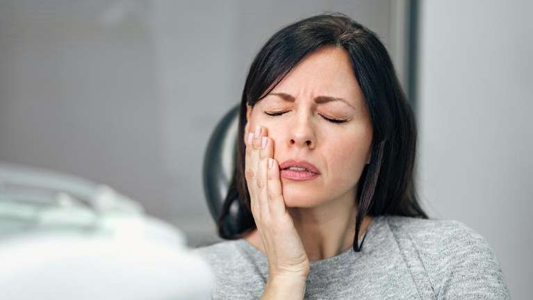 Female Patient suffering tooth pain in Winchester | Root Canal